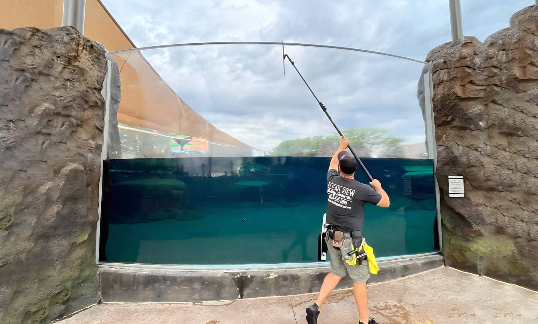 man washing large window